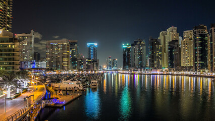 Obraz premium Dubai Marina towers and yachts in Dubai at night timelapse hyperlapse