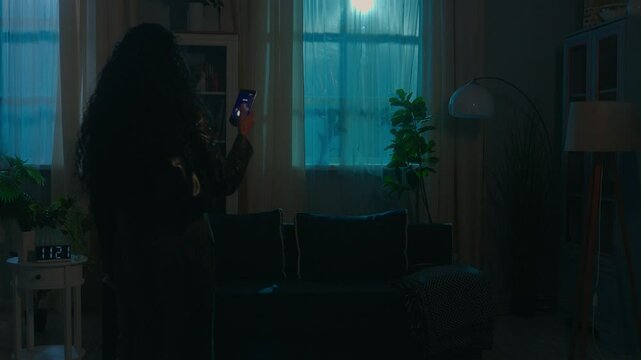 Smart home lighting system innovation technology power lamp woman walking in dark distant turning lightness electricity modern futuristic house night female girl use mobile phone turn light on control