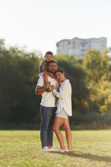 Three people. Mother and father are with son outdoors on the field