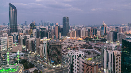 Modern city architecture of Abu Dhabi skyline day to night timelapse, UAE.