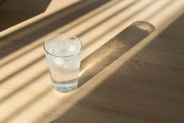 A glass of sparkling water on a wooden table.