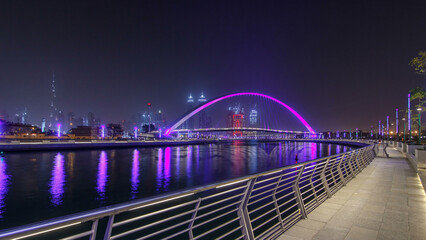 Obraz premium Pedestrian Bridge over the Dubai Water Canal night timelapse hyperlapse, United Arab Emirates