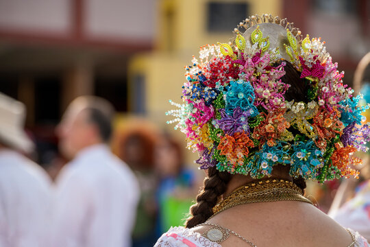 Young panamanian woman in a traditional white pollera with blue embroidery, colorful beaded headdress and jewelry, posing at a vibrant cultural festival, Panama - stock photo