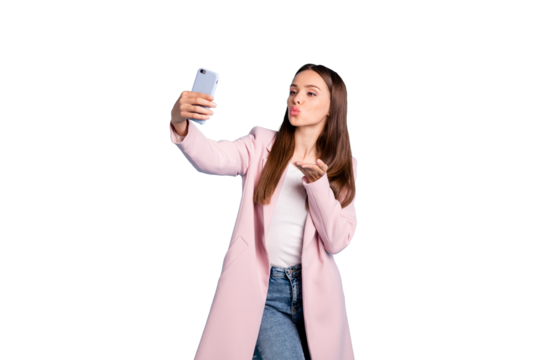 Portrait of cute charming lady sending air kisses to her boyfriend taking selfie wearing topcoat denim jeans isolated over blue  color background