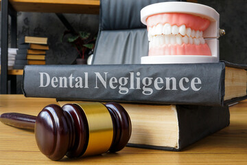 Model of a jaw and book with the inscription Dental negligence.