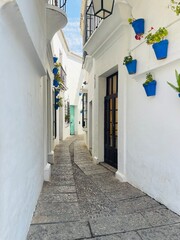 Calle estrecha del Poble Espanyol con jarrones azules