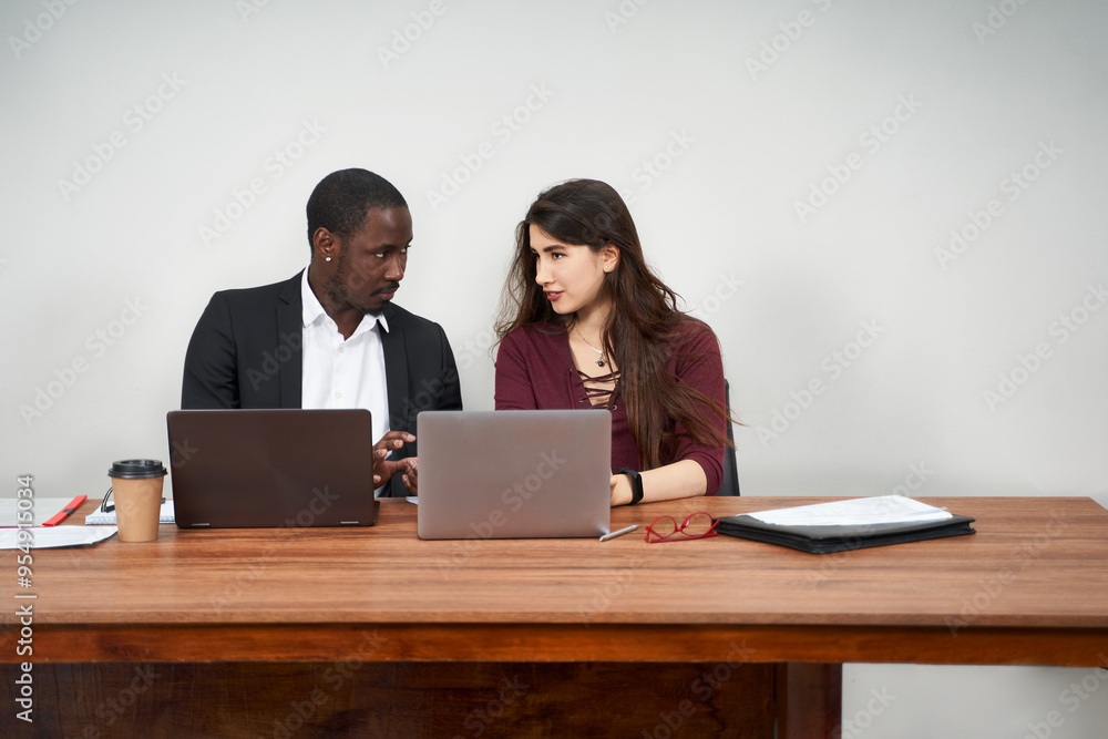 Wall mural Multiethnic Colleagues Use Cellphones and Try Smartphone Applications In Office