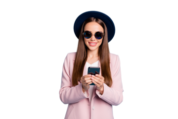 Portrait of cheerful positive girl in eyeglasses eyewear using  her mobile phone device following commenting posts wearing pink topcoat isolated over blue background