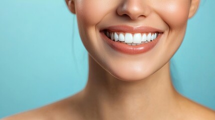 Obraz premium A close-up of a woman's radiant smile with perfectly white teeth, set against a smooth light blue background, symbolizing health and confidence.