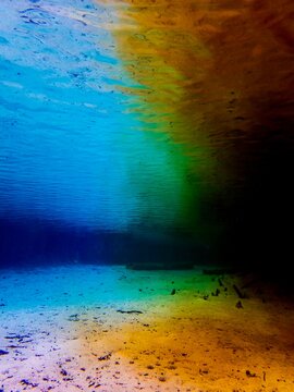Waters mixing as blue spring water hits murky orange river water at Ginnie Springs, High Spring, Alachua, Florida