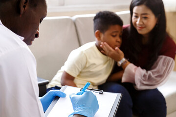 Obraz premium mother and her boy talk to african american pediatrician doctor for illness treatment in hospital. healthcare concept.