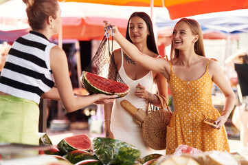 Buying fruits from the seller. Two women are together on the marker or bazaar