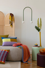 Contemporary interior design featuring a curved sofa, vibrant throw blankets, and geometric...
