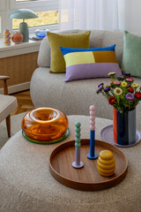 Cozy seating area with a mix of colorful cushions and decorative accents, including a modern vase...