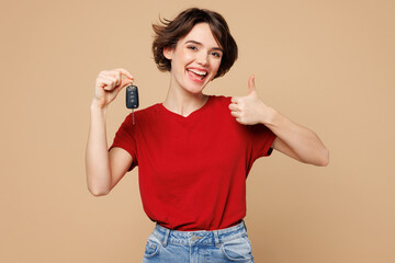 Young smiling happy woman she wear red t-shirt casual clothes hold in hand car key fob keyless...
