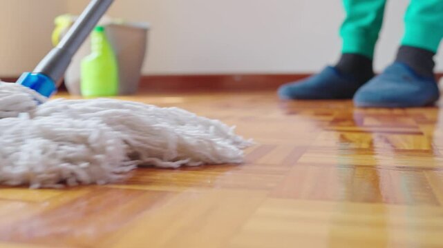 Closeup of Professional Cleaning Parquet Laminate Floor with Cotton Mop