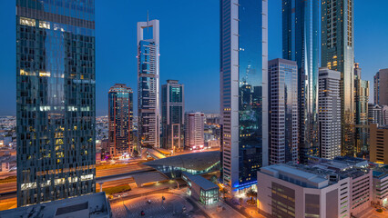 Obraz premium Skyline view of the buildings of Sheikh Zayed Road and DIFC day to night timelapse in Dubai, UAE.