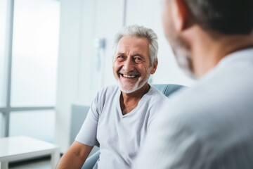 Fototapeta premium Elderly male doctor talking to patient in hospital
