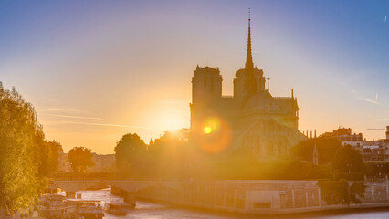 Fototapeta premium Rear view of Notre Dame De Paris cathedral at sunset with sun in the frame timelapse.