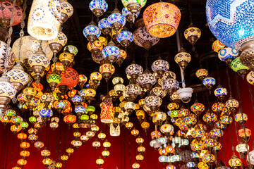 Traditional Turkish mosaic lamps, hundreds of colorful lamps hanging on a market stall in Global Village, Dubai, United Arab Emirates.