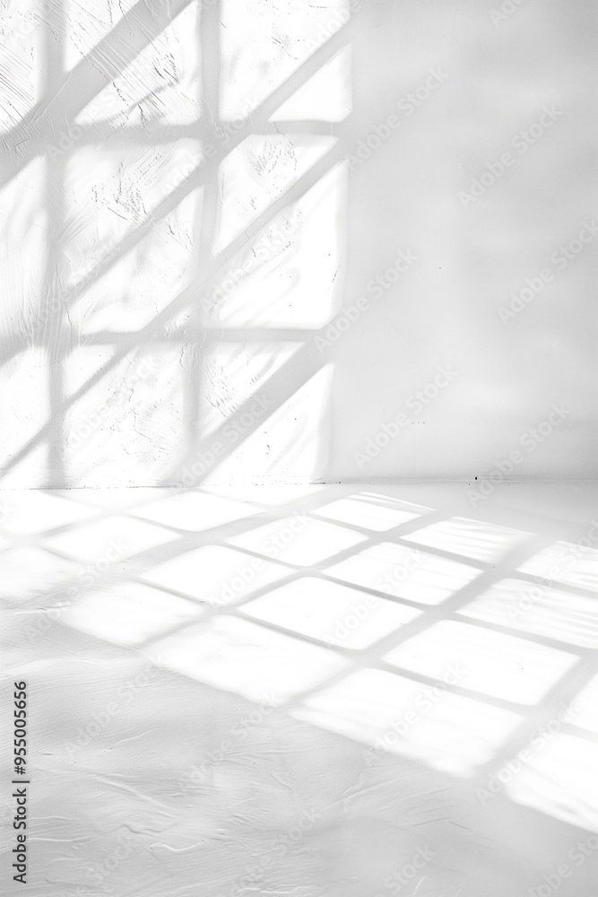 Poster sunlit empty room with shadows of window panes on white walls and floor.