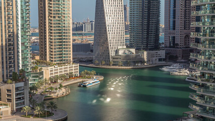 Fototapeta premium Aerial view of Dubai Marina residential and office skyscrapers with waterfront timelapse