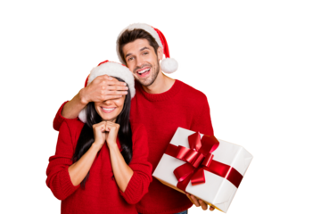 Portrait of charming guy in xmas cap hide his lovely sweethearts eyes give her package wear red sweater isolated over yellow background