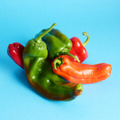 Assortment of long sweet peppers over blue background