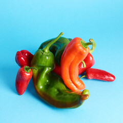 Assortment of long sweet peppers over blue background