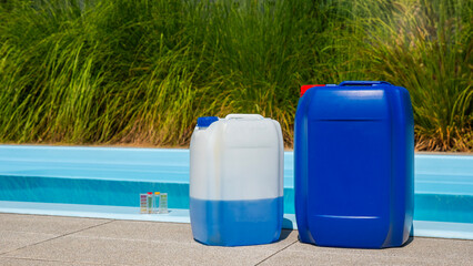 A poolside scene with chemical containers, a cleaning hose in the pool, and a water testing kit, showcasing pool maintenance activities.