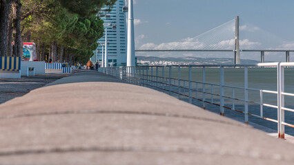 View from river Tagus waterfront of Lisbon's Nations park and Vasco da Gama Bridge timelapse, Portugal