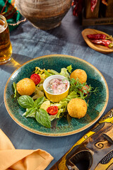 Appetizing Cheese Balls with Fresh Greens and Sauce on Rustic Plate