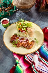 Appetizing Buffalo Wings with Cocktail Sauce and Vegetable Sticks on a Vibrant Plate