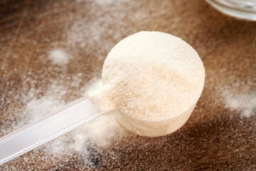 Collagen powder in a plastic measuring scoop on a table