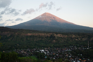 Drone Photo of Mount Agung at Sunrise with Pink-Tinted Peak.