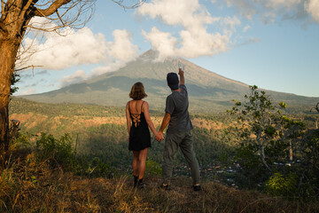 Couple Holding Hands with View of Mount Agung at Sunrise.