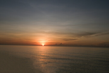 The sun rises at the sea in the morning.