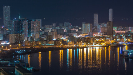 Cityscape of Ajman aerial view from rooftop at night timelapse. United Arab Emirates.