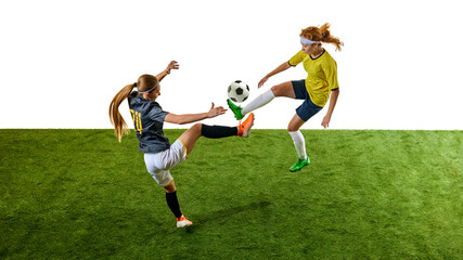 Young athletic women, mid-20s, soccer players, competing intensely on green turf, vying for ball control on green football field against white studio background. Concept of sport, tournament, event.