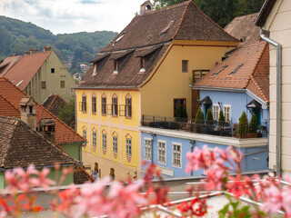 Uphill view on empty Sighisoara street with colorful medieval houses, Romania
