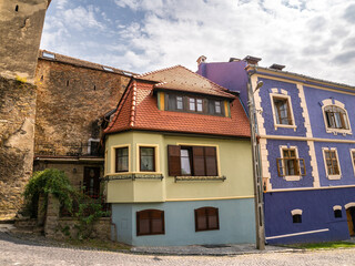 Uphill view on empty Sighisoara street with colorful medieval houses, Romania