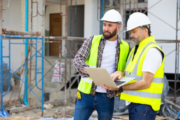 Two Professional Architects Engineer Working on Personal laptop computer at house construction site. Product quality Inspection