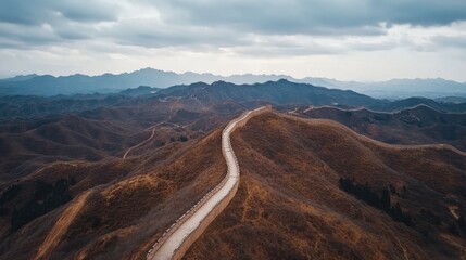 Aerial view of an empty Great Wall of China, stretching across the landscape with no people in sight, under a cloudy sky