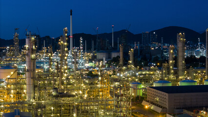 Fototapeta premium Oil Refinery plant at sunset. Gas Chemical Equipment Prodiction import export Concept, Crude Oil Refinery Plant Steel Pump Pipe line and Chimney and Cooling tower, Chemical Petrochemical