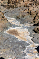 Wadi Shawka pools mountain trail in Hajar Mountains, United Arab Emirates, stony, dry riverbed in rocky valley.