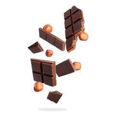 Pieces of tasty chocolate and hazelnuts falling on white background