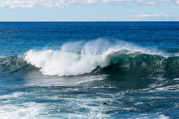 Onda spumeggiante in una giornata di sole