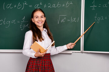 Photo of charming teen pupil girl hold book stick pointer wear trendy uniform classroom blackboard background