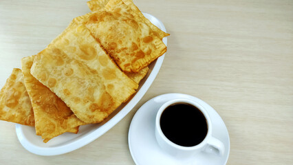 A plate full brazilian typical pastry called pastel and cup of coffee
