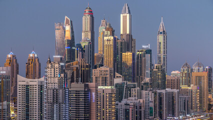 Dubai marina with traffic on sheikh zayed road panorama day to night timelapse lights turn on.